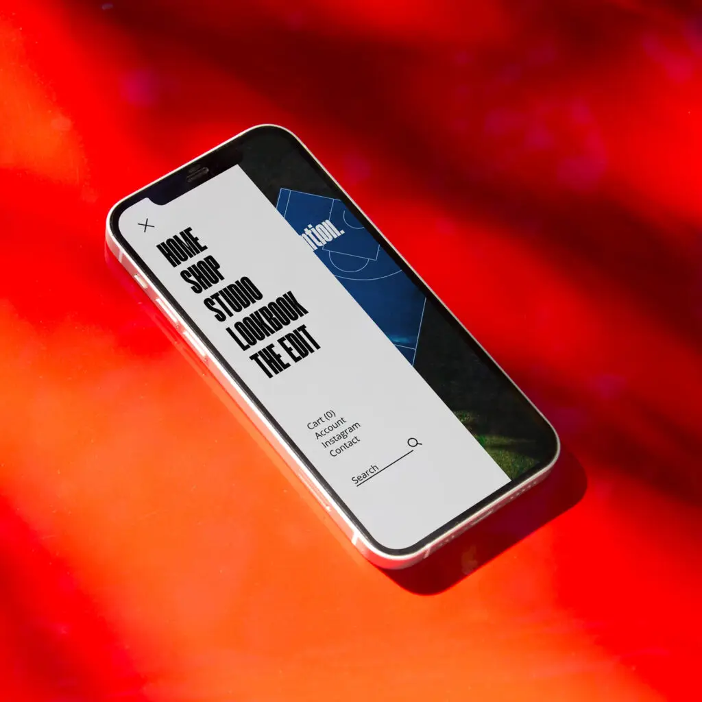 Mobile phone displaying a clean website design layout with menu and product visuals — web design showcase by Go Social Studios.
