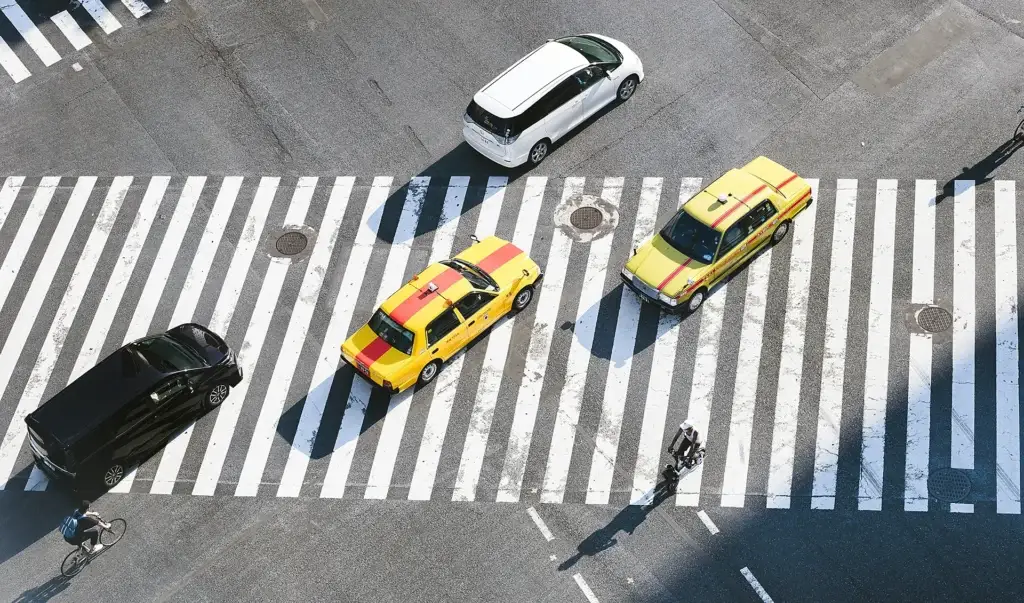 Two bold yellow cars standing out in a crosswalk among muted traffic — symbolizing Go Social Studios’ creative and standout approach.